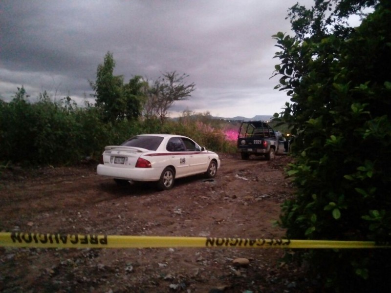 Encuentran a persona asesinada al interior de un taxi.