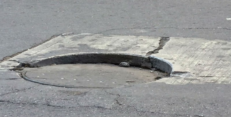 Una alcantarilla a punto de perder su tapadera