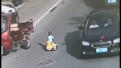Niño esquiva el tráfico sobre su auto de juguete