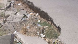 Se cae a pedazos calle a un costado de arroyo