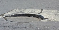 Una alcantarilla a punto de perder su tapadera