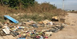 Lote baldío lleno de maleza y basura