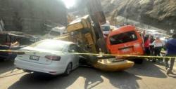 Retroexcavadora cae sobre automóviles